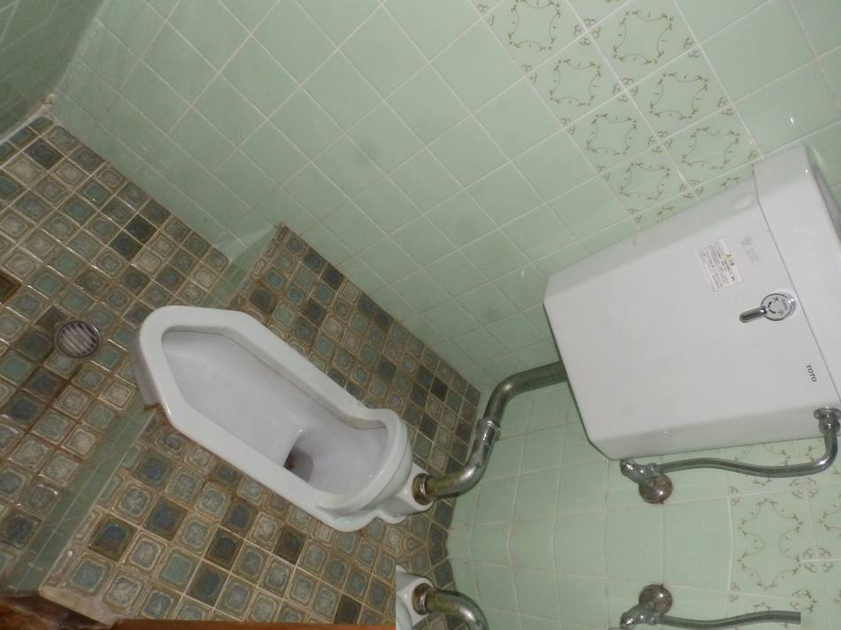 工事前のトイレ全景。段差のあるタイル床